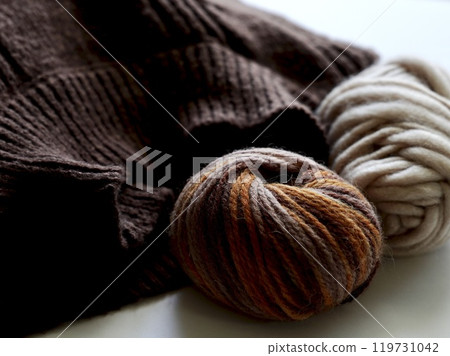 Two balls of yarn and a brown sweater 119731042