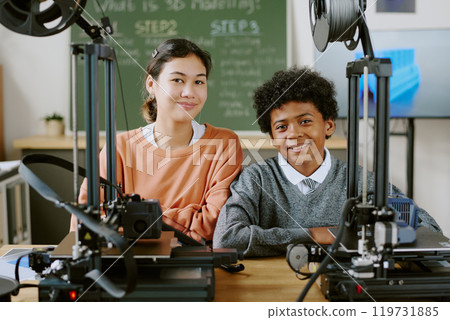 Multiracial students smiling while learning 3D printing technology in classroom setting. Diverse children engaging in hands-on activity involving 3D printers and related devices 119731885