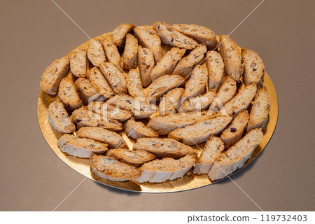 Almond cantucci biscuits in a circle on golden background highlighting rustic charm 119732403