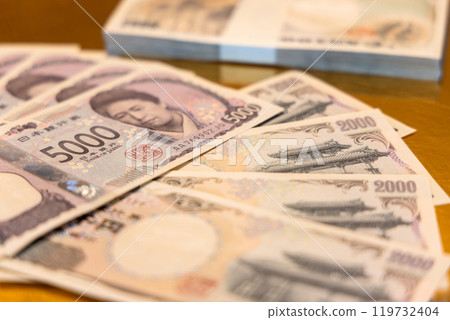 Selective focus on 5000 yen bill with blurred 2000 yen notes behind emphasizing intricate design 119732404
