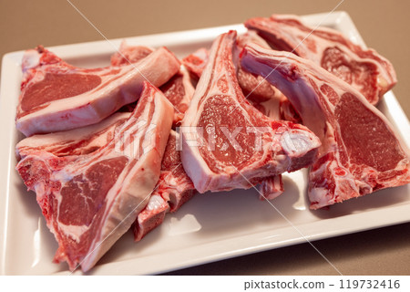 Raw lamb chops on white plate pink marbled meat visible fat  quality and nutritional value 119732416