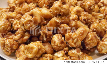Close up of crisp caramel popcorn that is coated in a sweet, thin candy shell from heated sugar or molasses syrup. A delightful treat. Close up of crisp caramel popcorn that is coated in a sweet, thin candy shell from heated sugar or molasses syrup. A delightful treat. 119733114