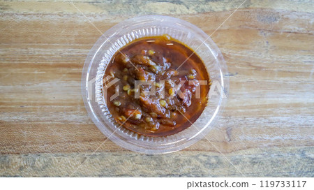 Sambal is Indonesian chili sauce made from peppers, shrimp paste, garlic, ginger, shallot, scallion, palm sugar, and lime juice. Adds spicy, flavorful kick to dishes. Sambal in a small plastic cup. Sambal is Indonesian chili sauce made from peppers, shrimp paste, garlic, ginger, shallot, scallion, palm sugar, and lime juice. Adds spicy, flavorful kick to dishes. Sambal in a small plastic cup. 119733117