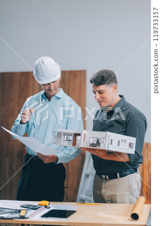 Team Engineers with draft plan of building on constructing site. Engineer work on site. engineer visit and inspection site engineer. Inspector engineer check and working on site. 119733157