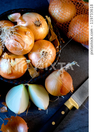 Brown onions and slices on wooden cutting board.Healthy food background. 119733618