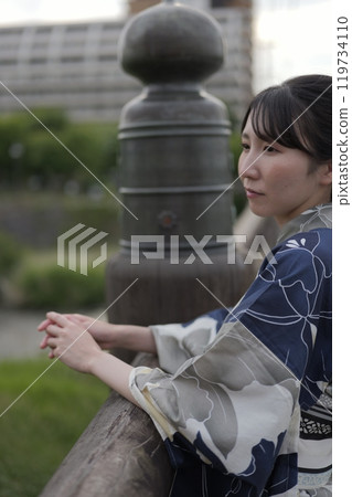 A young woman in a yukata standing on a bridge 119734110