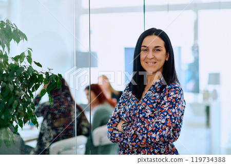 Portrait of a Confident Businesswoman with Crossed Arms in Her Office Environment. 119734388
