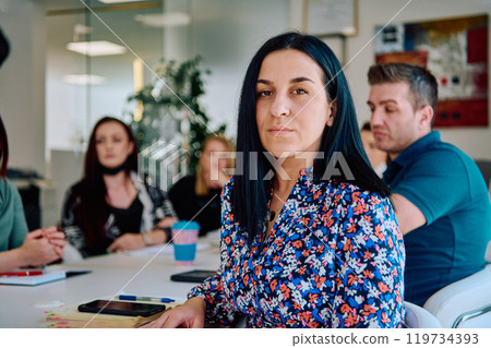 Diverse Business Team Discussing Projects in a Modern Glass Office. 119734393