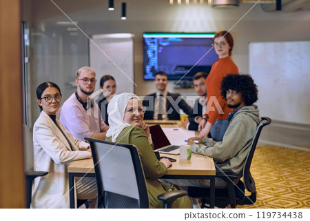 A diverse team of business experts in a modern glass office, attentively listening to a colleague's presentation, fostering collaboration and innovation. A diverse team of business experts in a modern glass office, attentively listening to a colleague's presentation, fostering collaboration and innovation. 119734438