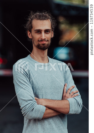 Portrait of a young successful businessman with crossed arms in front of the company 119734539