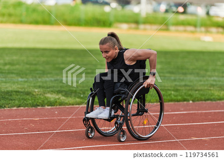 A woman with disablity driving a wheelchair on a track while preparing for the Paralympic Games A woman with disablity driving a wheelchair on a track while preparing for the Paralympic Games 119734561