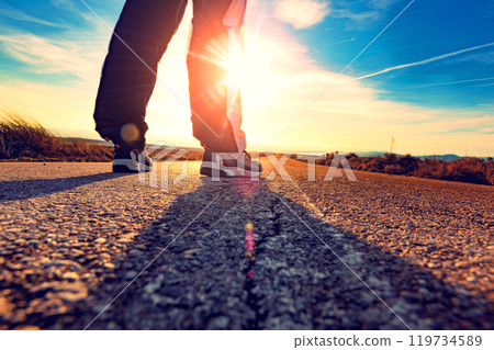 Travel man tourist alone on the road and sunset desert landscape. Travel man tourist alone on the road and sunset desert landscape. 119734589