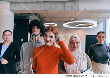 In the sleek corridors of a modern startup office, a diverse group of colleagues, led by their director, confidently stride forward, symbolizing collective success and the journey toward new business 119734717
