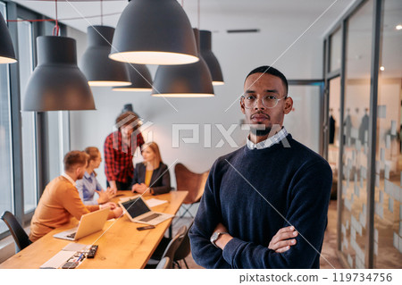 Startup Leadership: African American Businessman in Modern Office with Colleagues in Background. 119734756