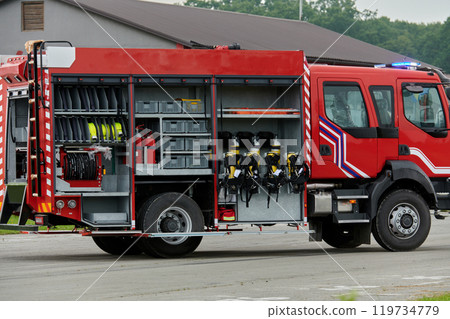 In this captivating scene, a state-of-the-art firetruck, equipped with advanced rescue technology, stands ready with its skilled firefighting team, prepared to intervene and respond rapidly to In this captivating scene, a state-of-the-art firetruck, equipped with advanced rescue technology, stands ready with its skilled firefighting team, prepared to intervene and respond rapidly to 119734779