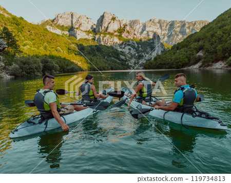 A group of friends enjoying having fun and kayaking while exploring the calm river, surrounding forest and large natural river canyons 119734813
