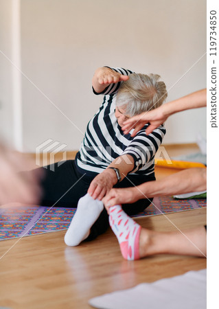 Senior Women Embrace Wellness: Yoga and Stretching in a Sunlit Space Senior Women Embrace Wellness: Yoga and Stretching in a Sunlit Space 119734850