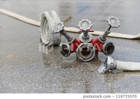Coiled Fire Hose Ready for Action on the Ground Coiled Fire Hose Ready for Action on the Ground 119735070