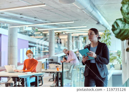 In the modern corporate world, a diverse group of businesspeople, representing various backgrounds and cultures, briskly walks through the hallway of a cutting-edge startup office, exemplifying In the modern corporate world, a diverse group of businesspeople, representing various backgrounds and cultures, briskly walks through the hallway of a cutting-edge startup office, exemplifying 119735126