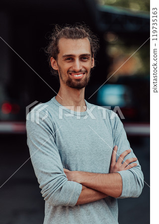 Portrait of a young successful businessman with crossed arms in front of the company 119735163