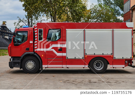 A state-of-the-art firetruck, equipped with advanced rescue technology, stands ready with its skilled firefighting team, prepared to intervene and respond rapidly to emergencies, ensuring the safety 119735176