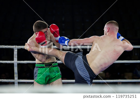 Fierce boxing match showcases athletes' power and skill. 119735251