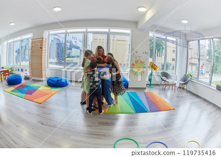 A child hugging a teacher in a modern kindergarten A child hugging a teacher in a modern kindergarten 119735416