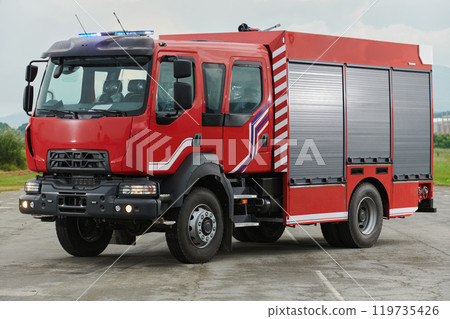 In this captivating scene, a state-of-the-art firetruck, equipped with advanced rescue technology, stands ready with its skilled firefighting team, prepared to intervene and respond rapidly to 119735426