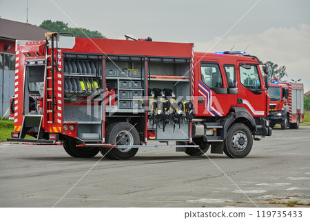 In this captivating scene, a state-of-the-art firetruck, equipped with advanced rescue technology, stands ready with its skilled firefighting team, prepared to intervene and respond rapidly to 119735433
