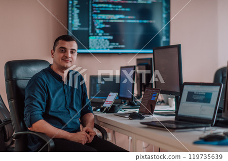 A programmer diligently testing smartphone applications while sitting in their office. 119735639