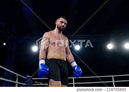 A determined boxer strides towards the ring, their eyes set on victory. A determined boxer strides towards the ring, their eyes set on victory. 119735693
