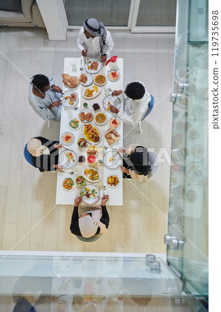 Top view of traditional and diverse Muslim family comes together to share a delicious iftar meal during the sacred month of Ramadan, embodying the essence of familial joy, cultural richness, and Top view of traditional and diverse Muslim family comes together to share a delicious iftar meal during the sacred month of Ramadan, embodying the essence of familial joy, cultural richness, and 119735698