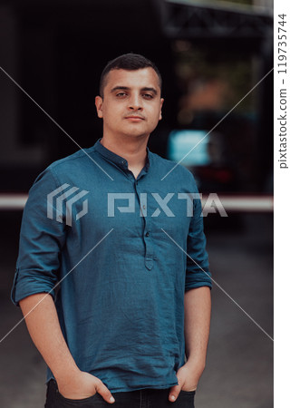 A portrait of a modern man, exuding confidence and style, against an outdoor backdrop, showcasing his charisma and fashionable demeanor. 119735744