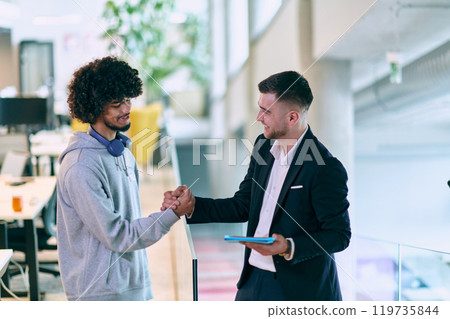In a modern office setting, an African American businessman and his director confidently extend their hands in congratulations, symbolizing successful resolution of a business problem, amidst a In a modern office setting, an African American businessman and his director confidently extend their hands in congratulations, symbolizing successful resolution of a business problem, amidst a 119735844