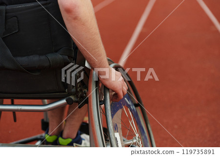 Close up photo of a person with disability in a wheelchair training tirelessly on the track in preparation for the Paralympic Games 119735891