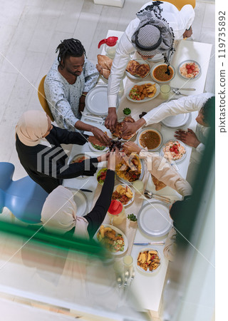 Top view of diverse hands of a Muslim family delicately grasp fresh dates, symbolizing the breaking of the fast during the holy month of Ramadan, capturing a moment of cultural unity, shared tradition 119735892