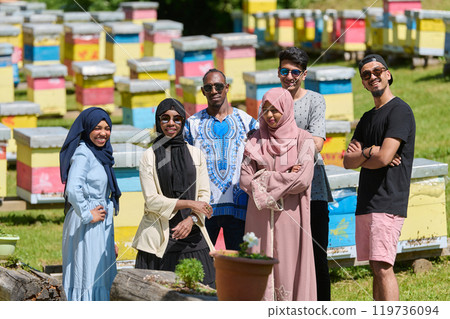 A diverse group of young friends and entrepreneurs explore small honey production businesses in the natural setting of the countryside. 119736094