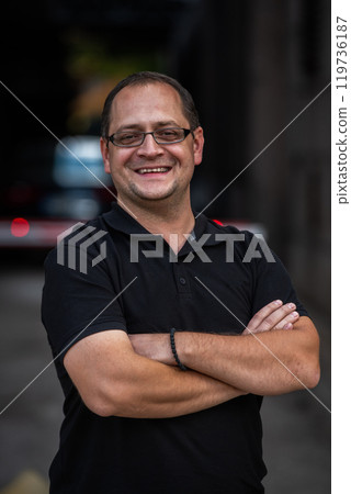 A successful businessman with crossed arms, posing outdoors A successful businessman with crossed arms, posing outdoors 119736187