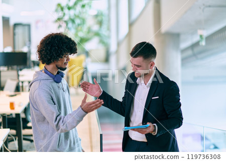 In a modern office setting, an African American businessman and his director confidently extend their hands in congratulations, symbolizing successful resolution of a business problem, amidst a In a modern office setting, an African American businessman and his director confidently extend their hands in congratulations, symbolizing successful resolution of a business problem, amidst a 119736308