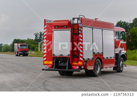 In this captivating scene, a state-of-the-art firetruck, equipped with advanced rescue technology, stands ready with its skilled firefighting team, prepared to intervene and respond rapidly to 119736313