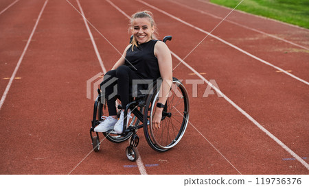 A woman with disablity driving a wheelchair on a track while preparing for the Paralympic Games 119736376