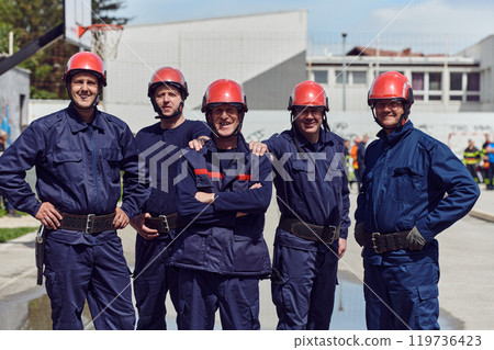 A team of confident and accomplished firefighters strides purposefully in their uniforms, exuding pride and satisfaction after successfully completing a challenging firefighting mission 119736423
