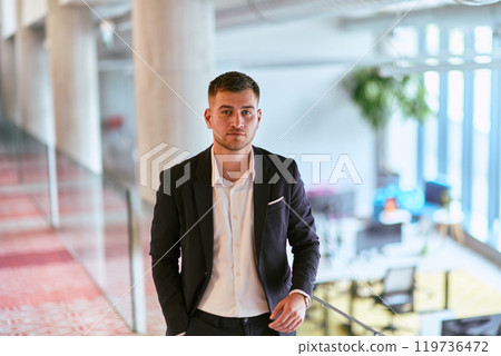 In a sleek corporate setting, the young and charismatic director strides confidently down the hallway, symbolizing his dynamic leadership and the promise of continued success within the company he In a sleek corporate setting, the young and charismatic director strides confidently down the hallway, symbolizing his dynamic leadership and the promise of continued success within the company he 119736472