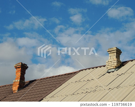 roof of a private village house divided between two owners with different coverings and shapes and materials of chimneys 119736619