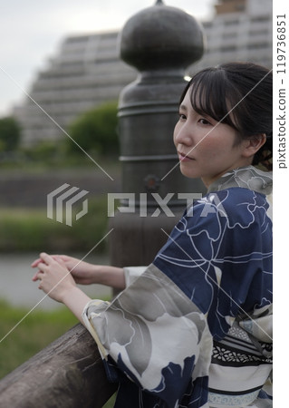 A young woman in a yukata standing on a bridge A young woman in a yukata standing on a bridge 119736851