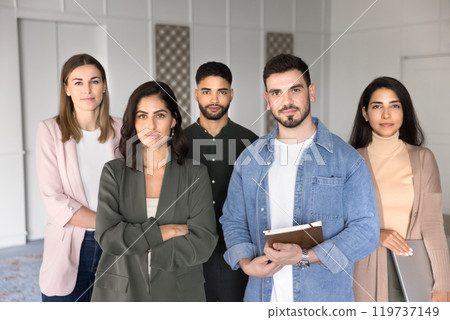 Successful multiethnic team of confident business professionals standing in office 119737149