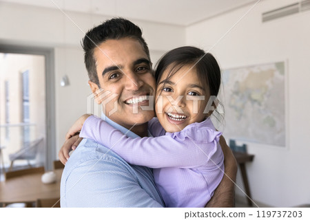 Portrait of cheerful Indian daddy hugging sweet preschool daughter kid 119737203