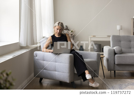 Aged female use laptop to buy goods at virtual marketplace Aged female use laptop to buy goods at virtual marketplace 119737272
