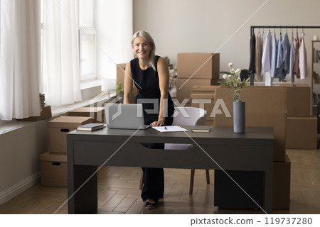 Senior female owner standing at table in stock trading office 119737280