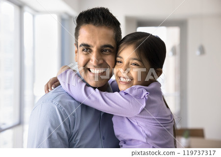 Happy loving 40s Indian dad holding daughter girl in arms Happy loving 40s Indian dad holding daughter girl in arms 119737317